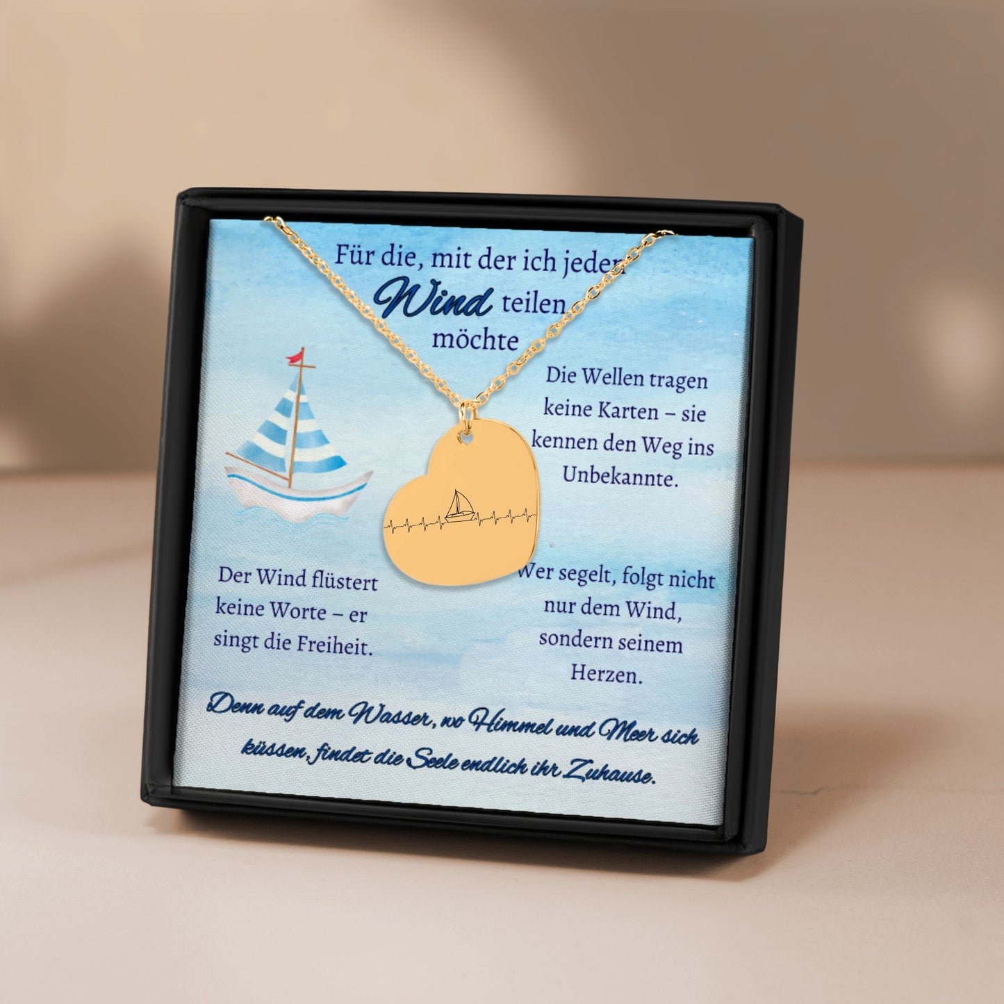 Herz-Halskette mit lasergraviertem Segelboot-Motiv im Herzschlag-Stil, präsentiert in einer schwarzen Geschenkbox mit blauem Hintergrund und poetischen Texten über Wind, Meer und Liebe. Der Anhänger ist herzförmig, 20 x 25 mm groß, aus Edelstahl in Silber, 18 Karat rosègoldplattiert oder 18 Karat vergoldet. Die Kette ist 45 cm lang, mit 5 cm Verlängerung. Ideal als personalisiertes Liebesgeschenk oder zu Weihnachten.