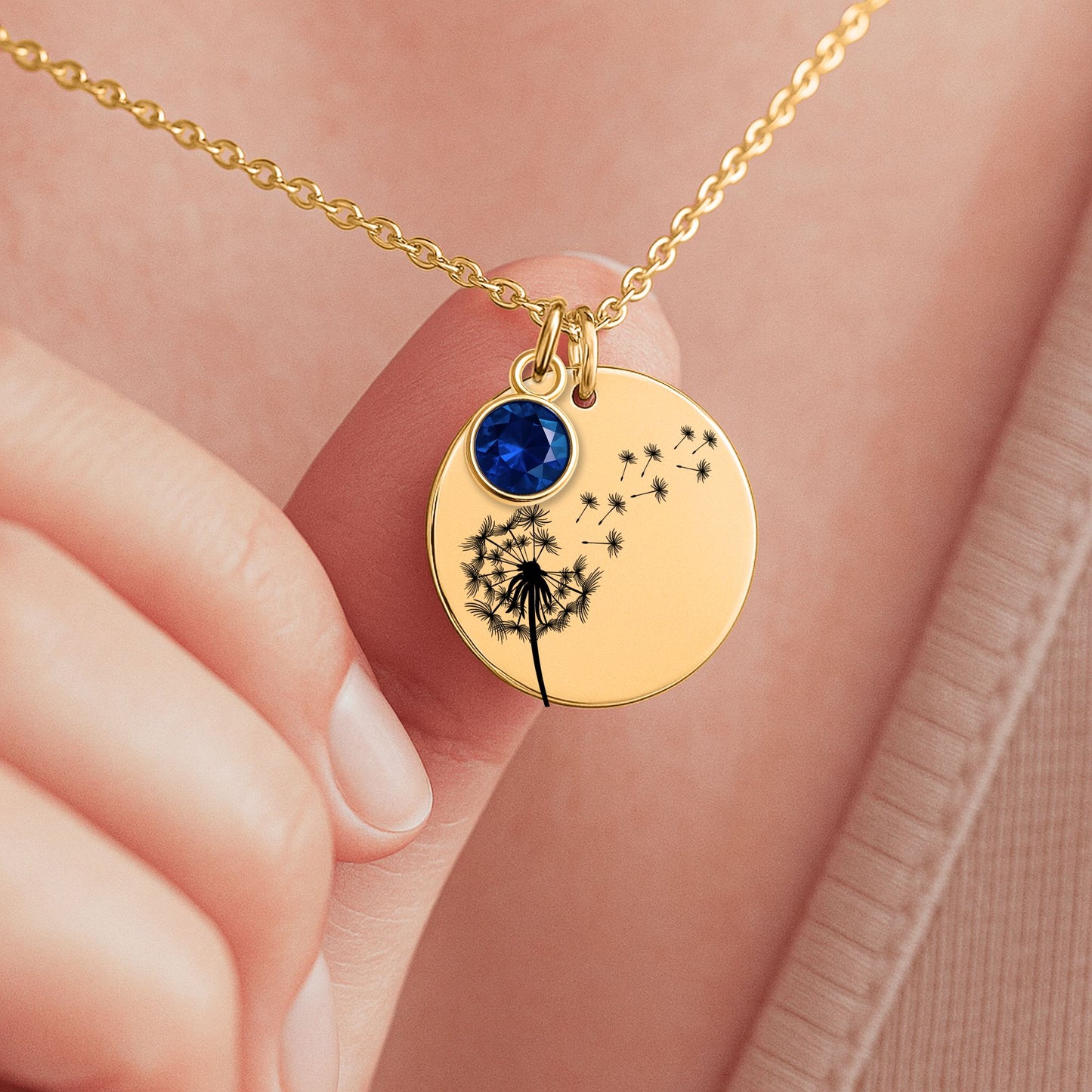 Ein goldenes Collier mit einem runden Anhänger, verziert mit Geburtsstein und einem zarten Pusteblumenmotiv, ruht in einer eleganten schwarzen Geschenkbox. Die Box enthält eine herzliche Botschaft von den Eltern an ihre Tochter, die die tiefe Liebe und den Wunsch ausdrückt, ihr das Beste im Leben zu geben. Die Rückseite des Anhängers ist personalisierbar, ideal für eine Gravur, die diese liebevolle Botschaft oder ein besonderes Datum für immer festhält und das Schmuckstück unvergesslich macht.