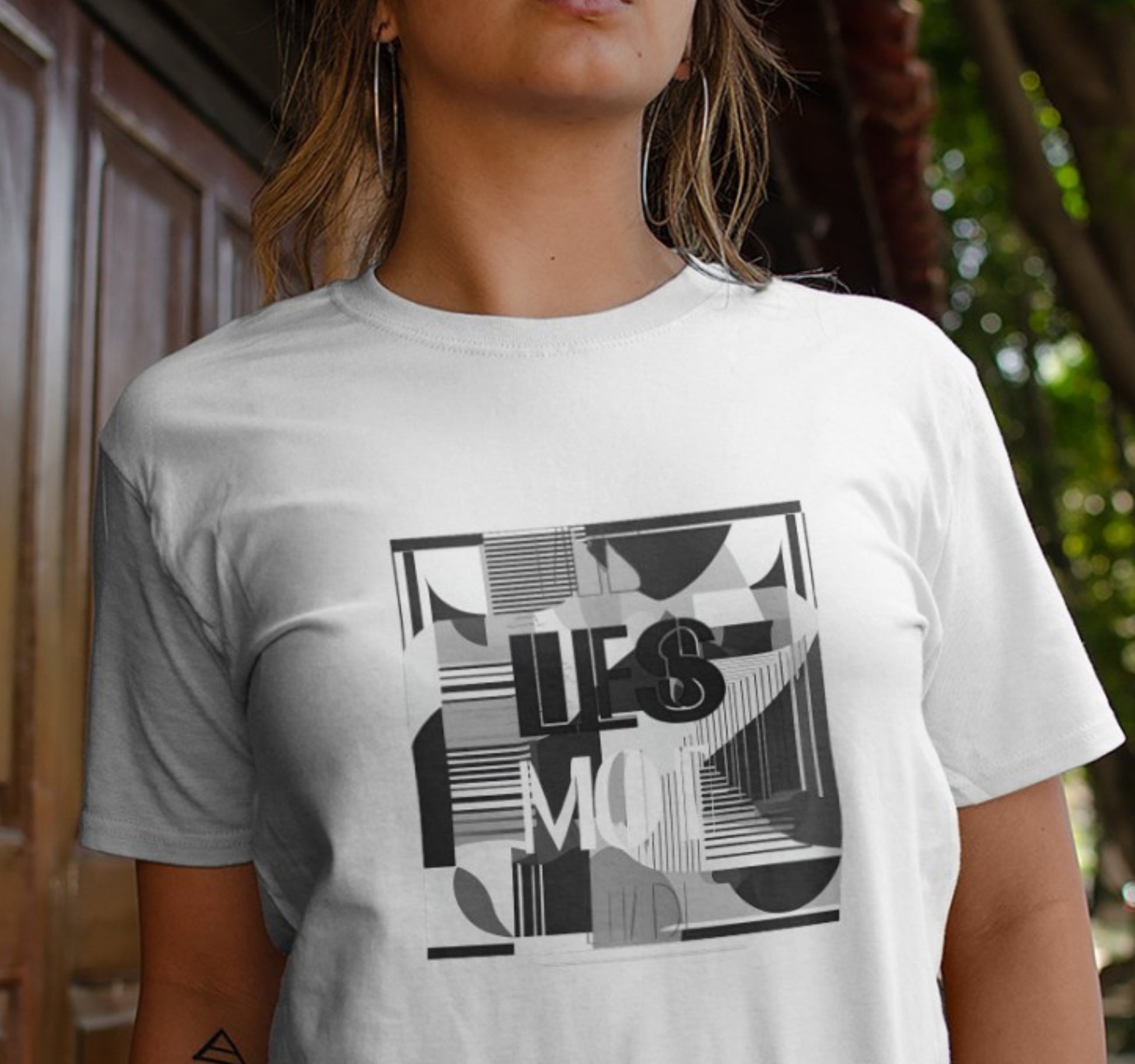 Ein Unisex T-Shirt mit minimalistischer schwarz-weißes Grafik aus klaren Linien und geometrischen Formen. Der Spruch "less is more" ziert das Shirt, ideal für 80er und 90er Partys, als Vintage-Geschenk für Frauen und Männer.