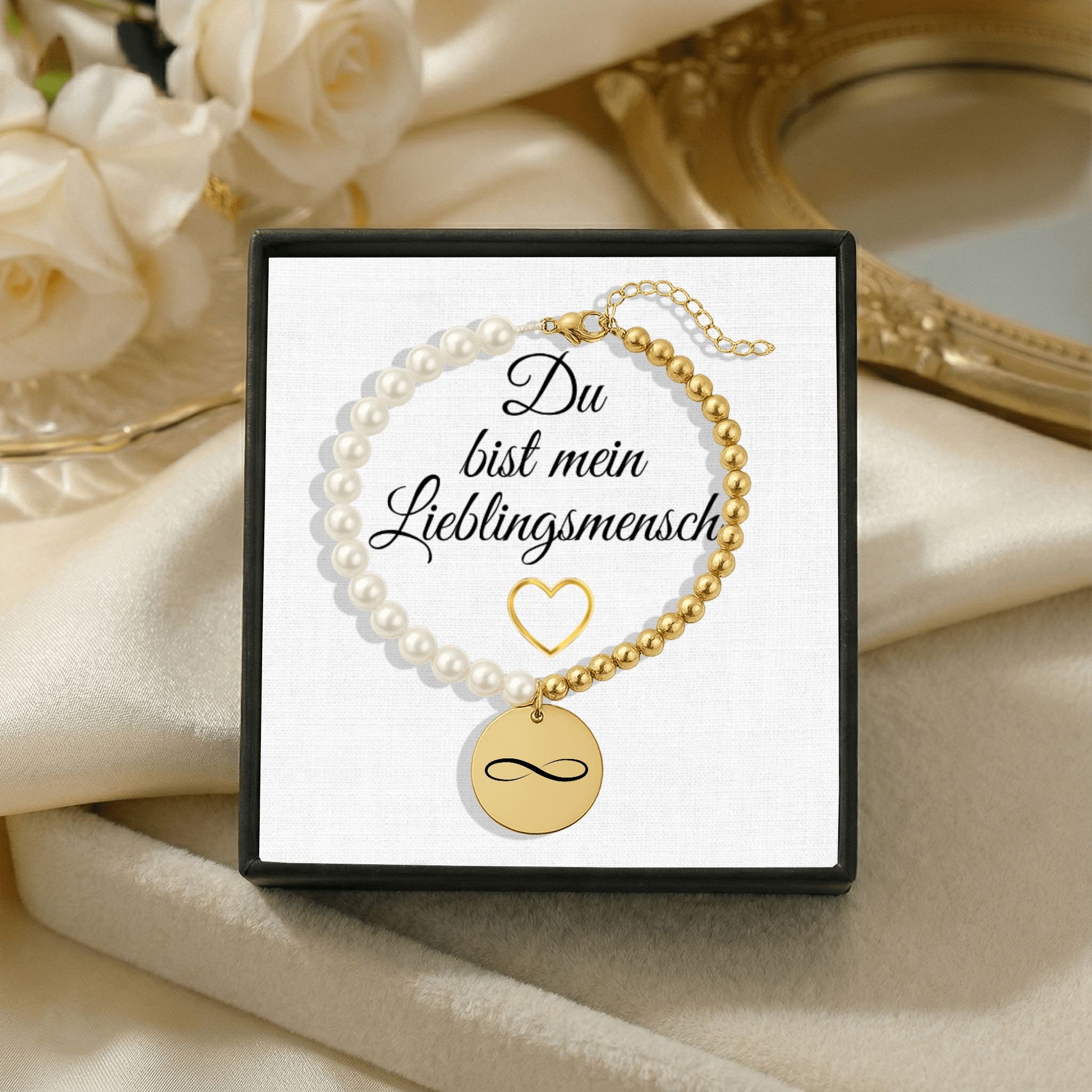 Personalisiertes Perlenarmband mit Namen, bestehend aus weißen Perlmuttperlen und goldfarbenen Edelstahlperlen, mit rundem gravierten Münzanhänger in Gold. Präsentiert in einer eleganten Geschenkbox mit der Aufschrift „Du bist mein Lieblingsmensch“. Emotionales Schmuckgeschenk, ideal als personalisiertes Armband, Namensarmband oder Geschenk zum Valentinstag und Jahrestag.