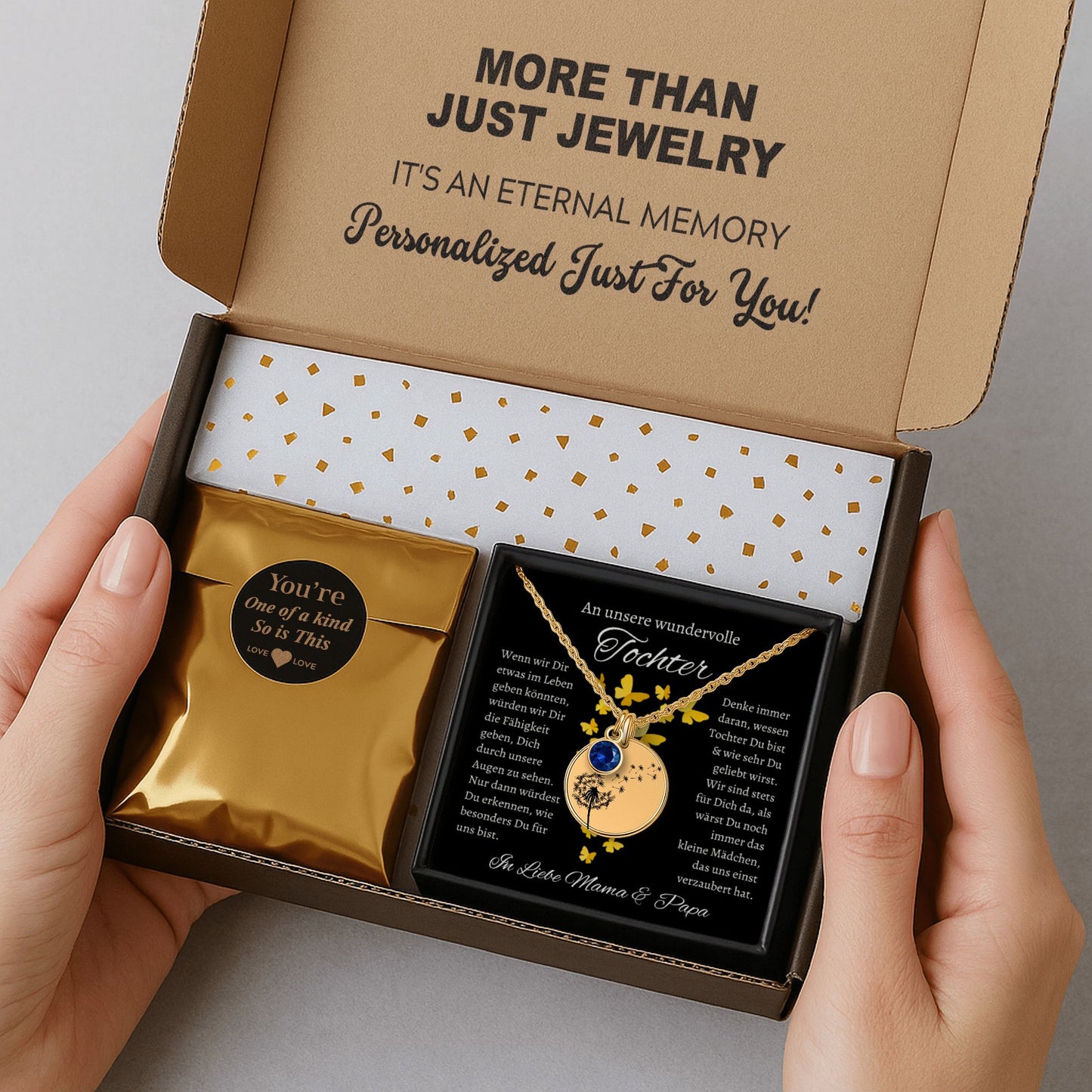 Ein goldenes Collier mit einem runden Anhänger, verziert mit Geburtsstein und einem zarten Pusteblumenmotiv, ruht in einer eleganten schwarzen Geschenkbox. Die Box enthält eine herzliche Botschaft von den Eltern an ihre Tochter, die die tiefe Liebe und den Wunsch ausdrückt, ihr das Beste im Leben zu geben. Die Rückseite des Anhängers ist personalisierbar, ideal für eine Gravur, die diese liebevolle Botschaft oder ein besonderes Datum für immer festhält und das Schmuckstück unvergesslich macht.