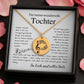 Eine goldene Halskette mit einem runden Anhänger, der mit einem Notenschlüssel und Musiknoten graviert ist. Die Kette wird in einer edlen, schwarzen Geschenkbox auf einer Karte mit einem inspirierenden, emotionalen Spruch präsentiert. Die liebevolle Aufmachung mit zarten Blütenblättern im Hintergrund positioniert den Schmuck als hochwertiges und bedeutungsvolles Geschenk für einen besonderen Menschen.