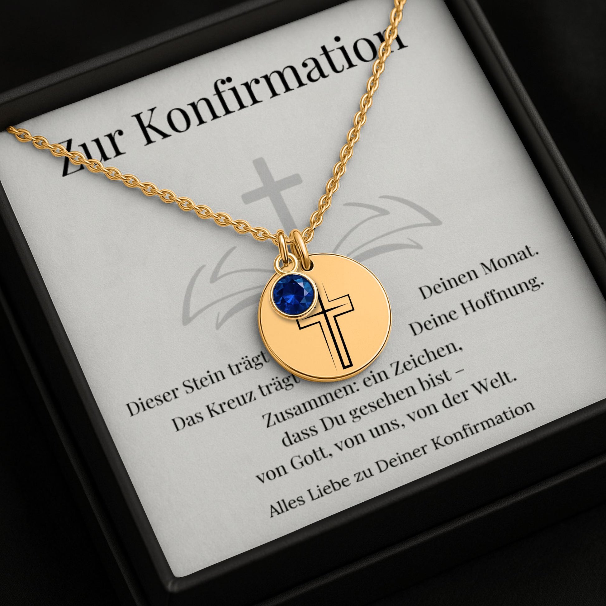 Personalisierte Konfirmationskette mit Kreuz-Anhänger und Geburtsstein in goldener Fassung, präsentiert in einer eleganten schwarzen Geschenkbox mit herausnehmbarer Karte. Im Hintergrund dunkler Hintergrund. Ideal als Geschenk zur Konfirmation, Firmung oder Geburtstag für junge Frauen.