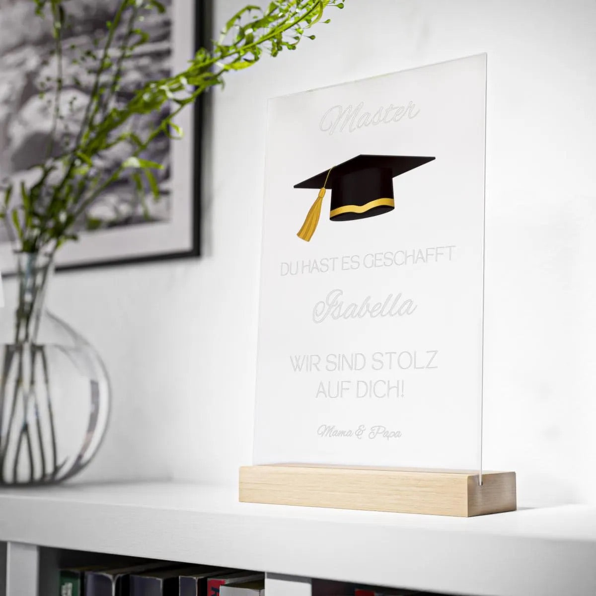 Persönliche Acryltafel mit Name, „Master“-Text, Doktorhut in Schwarz-Gold und individueller Widmung – ein emotionales Geschenk zum Abschluss. Optional Holzsockel mit LED-Lichtern für stimmungsvolle Beleuchtung. Hochwertig gefertigt aus klarem Acryl, ideal als dauerhafte Erinnerung auf Schreibtisch oder Regal. Perfekt als Geschenkidee zum Master, Bachelor oder Doktor – persönlich, edel und langlebig. Ein Geschenk, das Herzen berührt und Erfolge dauerhaft feiert.