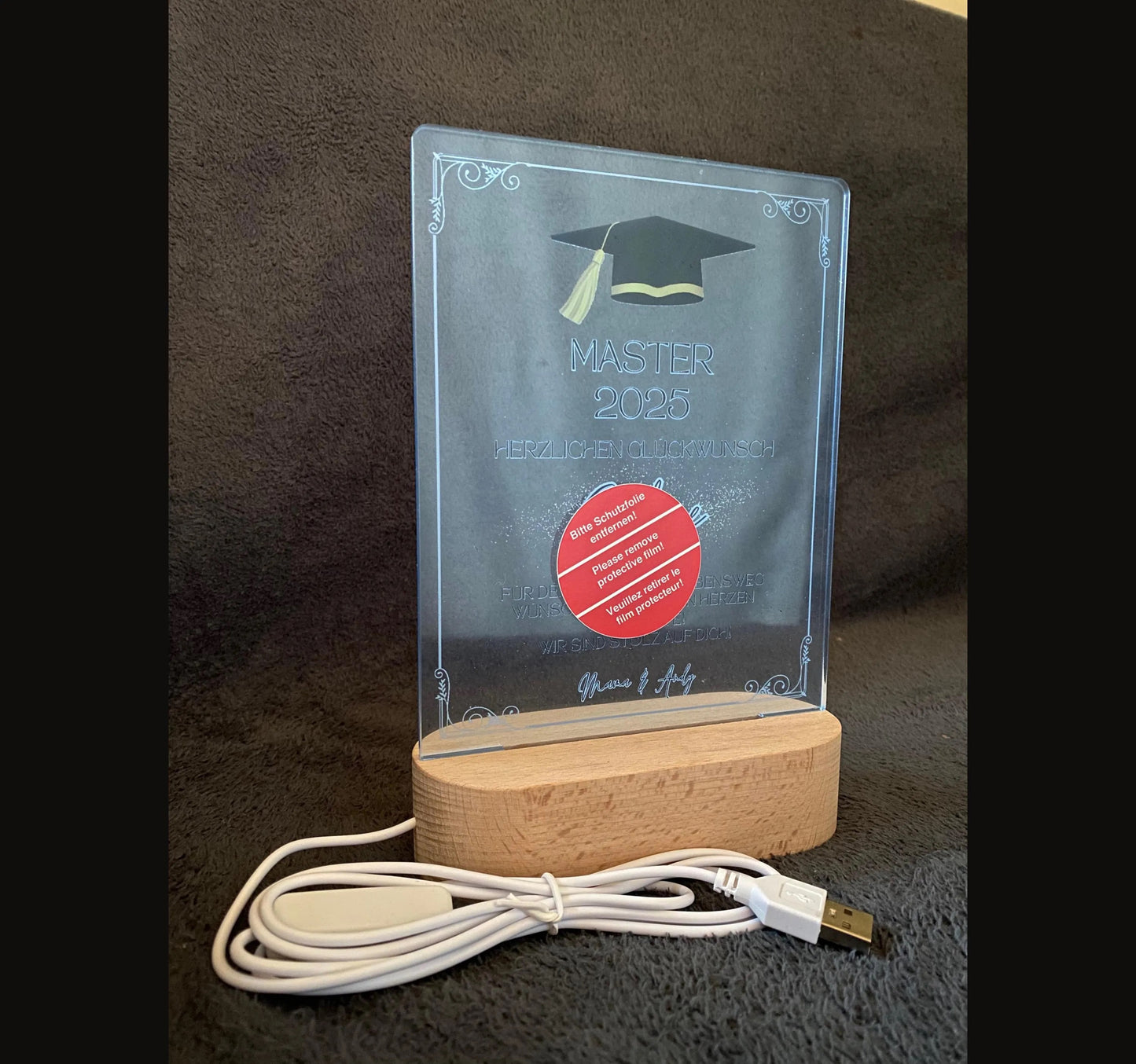 Persönliche Acryltafel mit Name, „Master“-Text, Doktorhut in Schwarz-Gold und individueller Widmung – ein emotionales Geschenk zum Abschluss. Optional Holzsockel mit LED-Lichtern für stimmungsvolle Beleuchtung. Hochwertig gefertigt aus klarem Acryl, ideal als dauerhafte Erinnerung auf Schreibtisch oder Regal. Perfekt als Geschenkidee zum Master, Bachelor oder Doktor – persönlich, edel und langlebig. Ein Geschenk, das Herzen berührt und Erfolge dauerhaft feiert.